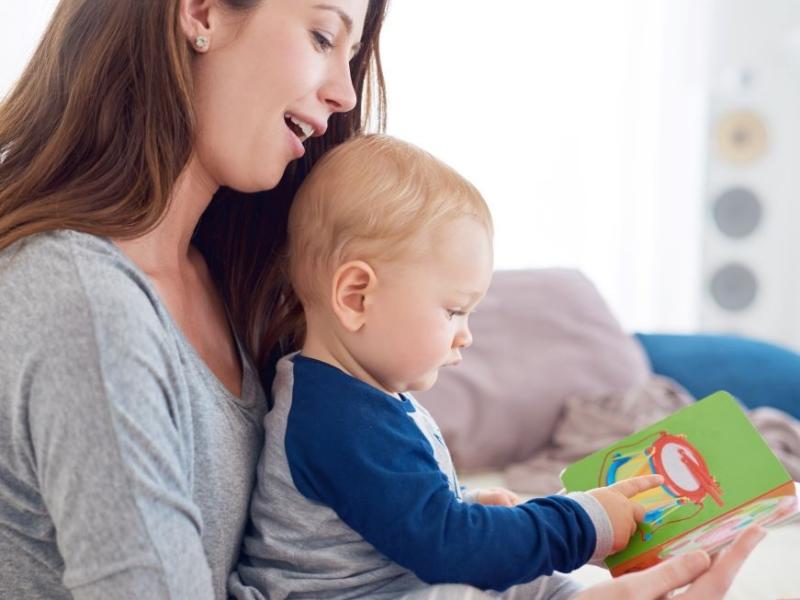 En mor læser med sit lille barn